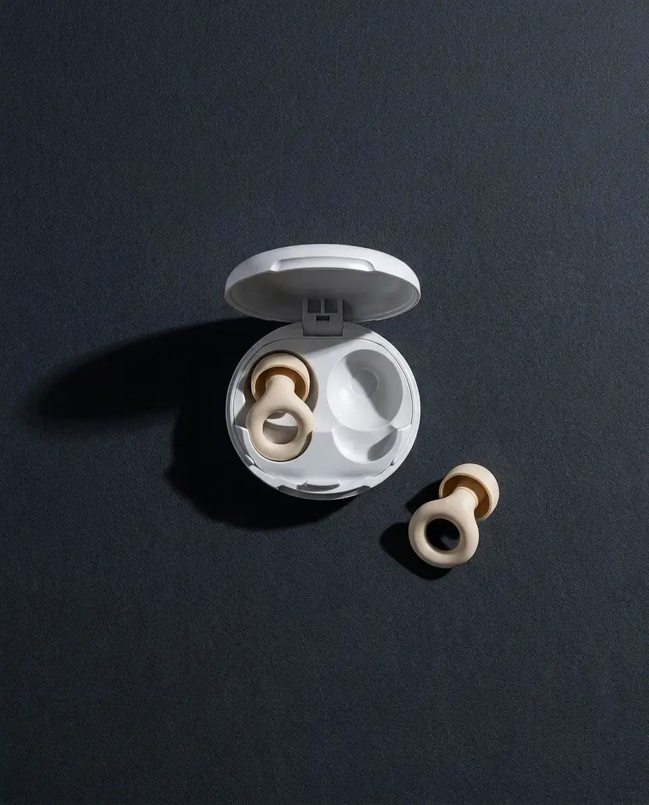 A Vespré earplug case open on a dark surface beside a single earplug