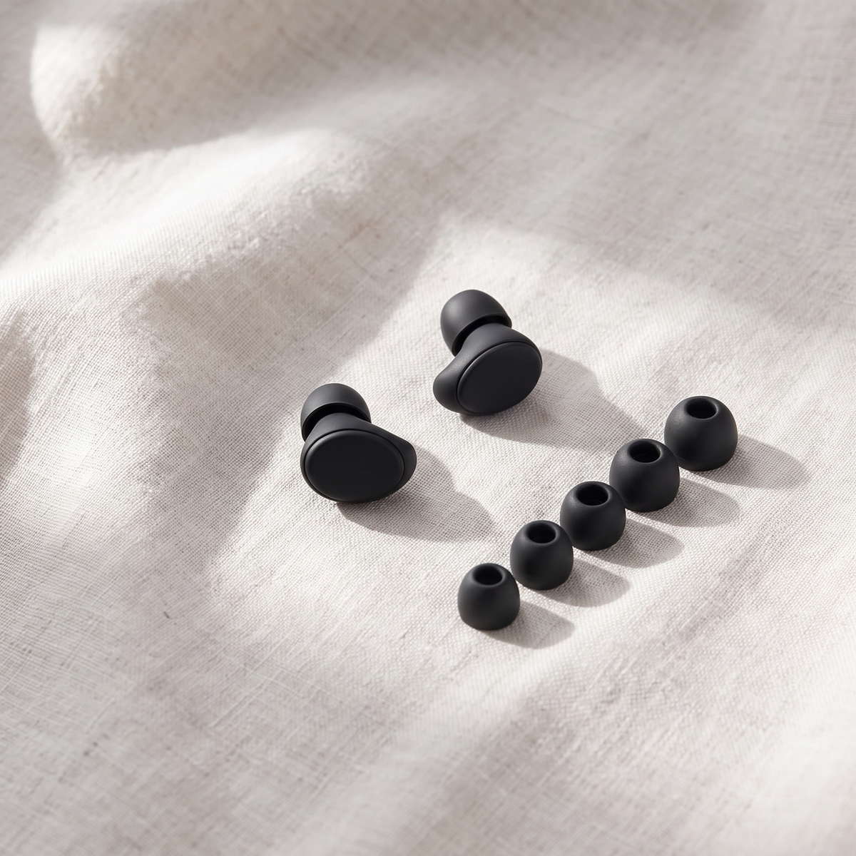 Two Vespré Rest earplugs beside spare tips from smallest to largest