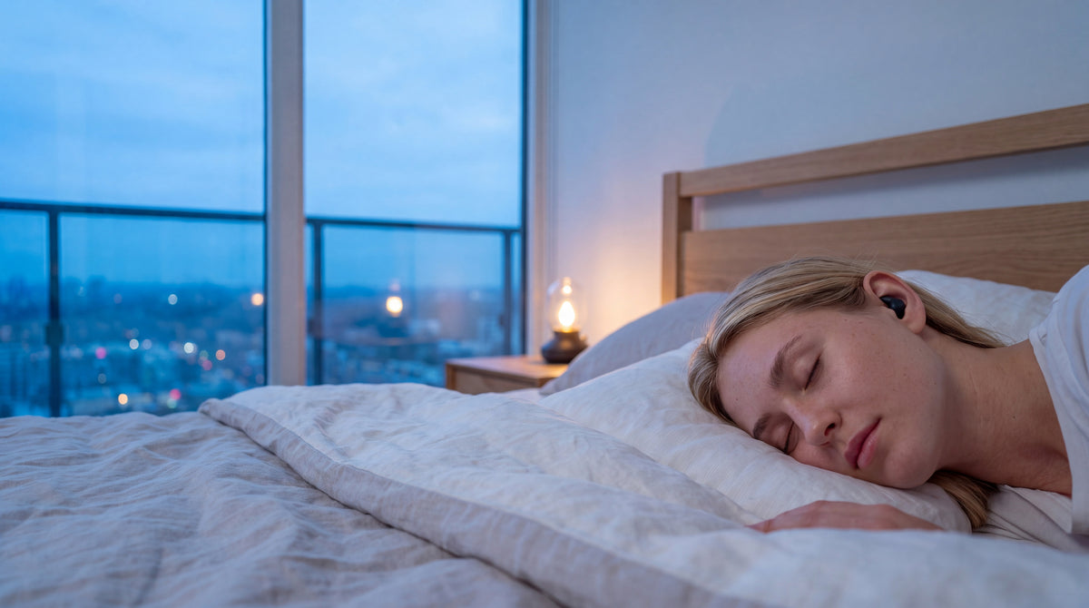 A young woman asleep in a city apartment at dusk, a Vespré Wing earplug in her ear