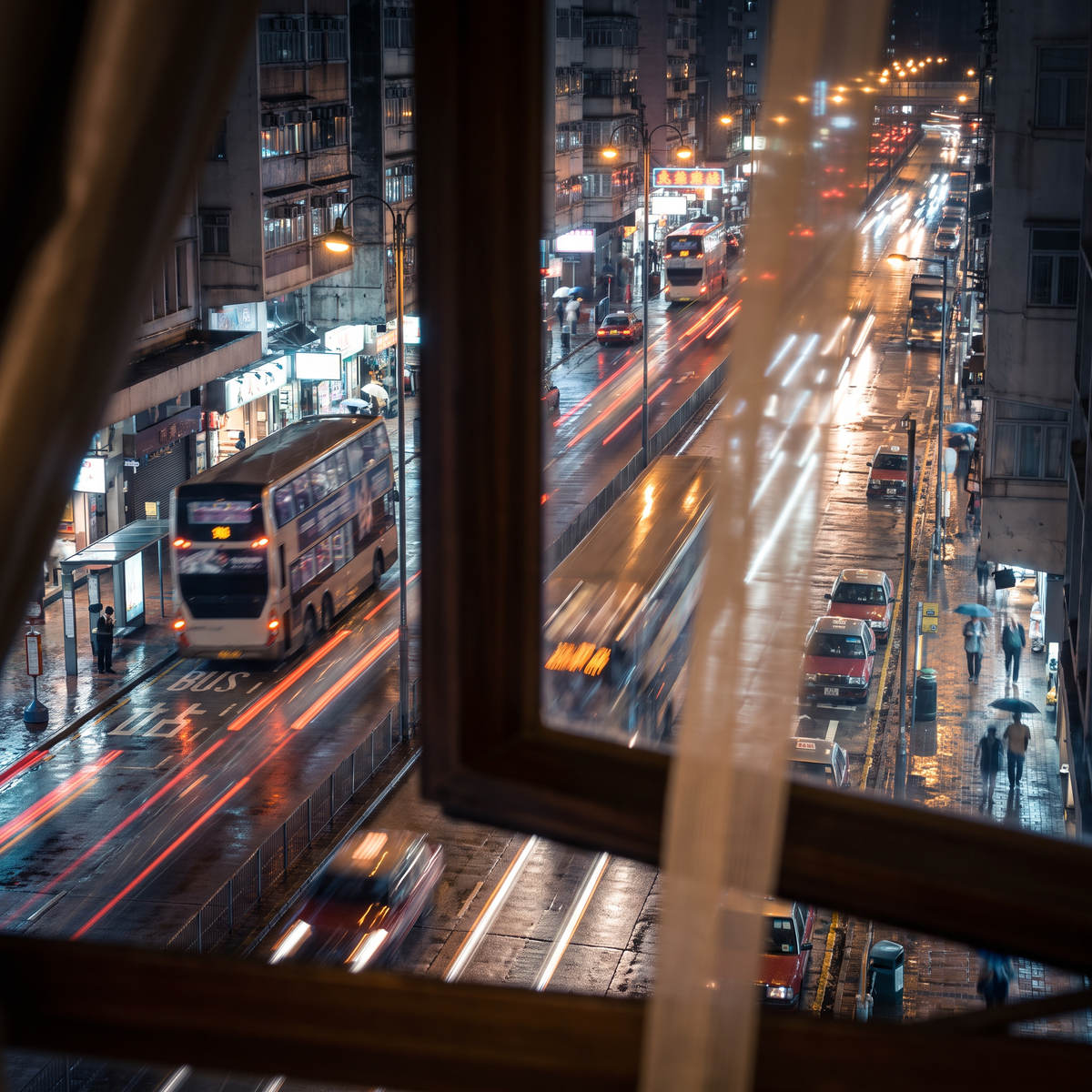 A busy city street at night seen from a bedroom window